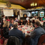 People eating food in a Christmas dining hall.