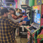 People playing the Area 51 arcade game
