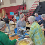 People in hair nets serving food